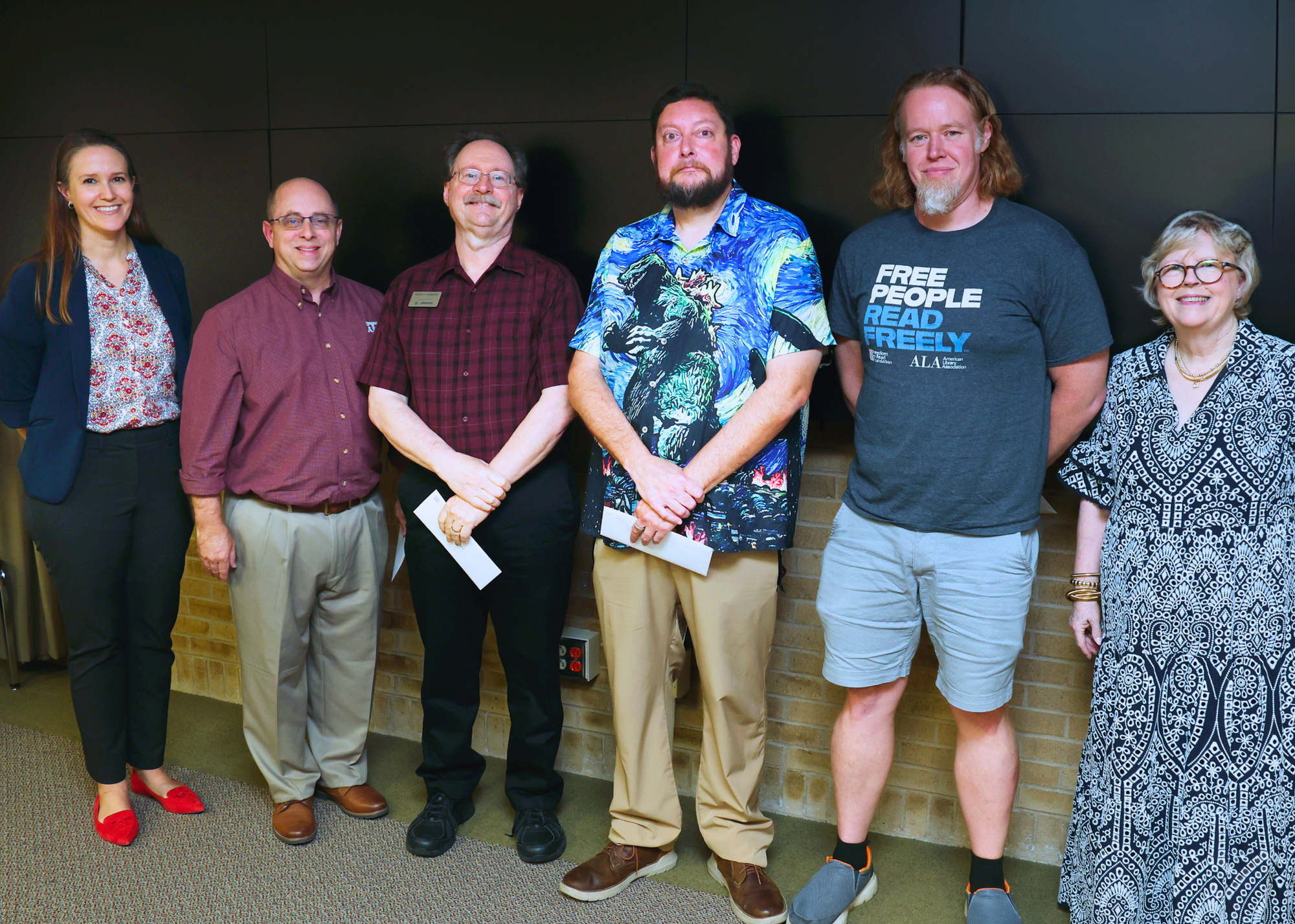 Longevity service award winners standing between the University Librarian and a representative from the Friends of the Texas A&M University Libraries.